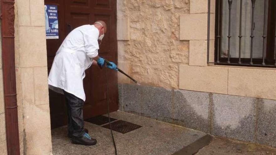 Un operario limpia una fachada de piedra en la capital.