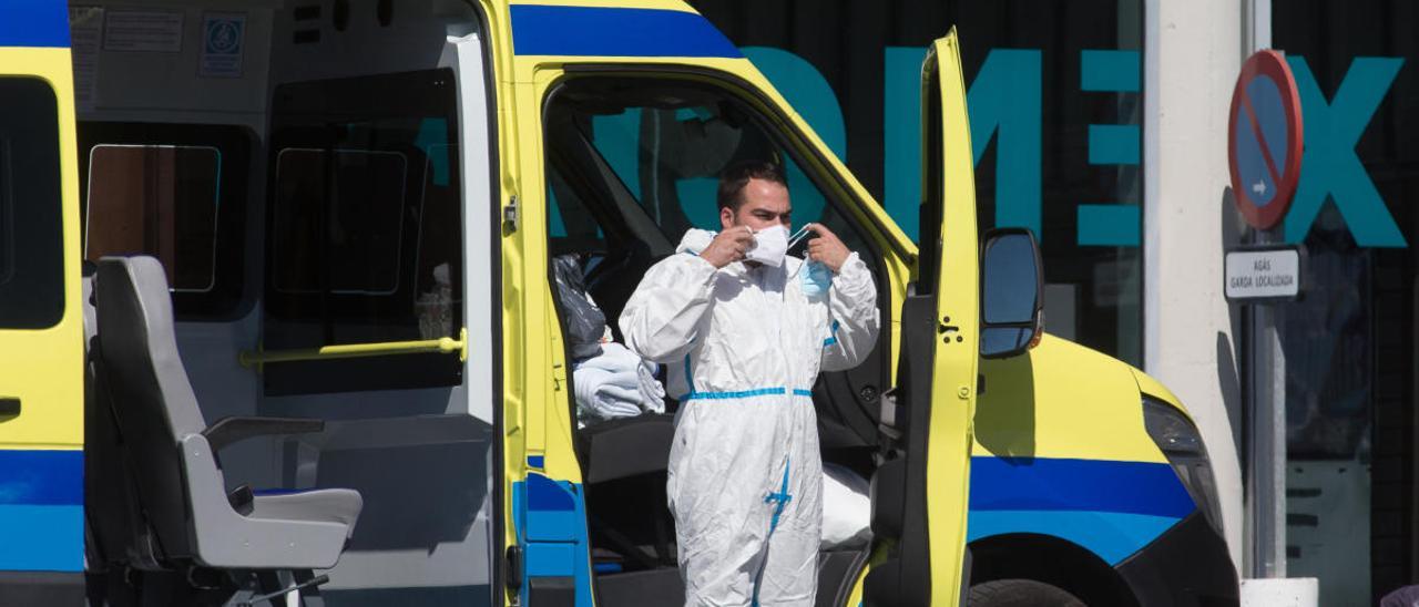 Un profesional sanitario baja de una ambulancia.