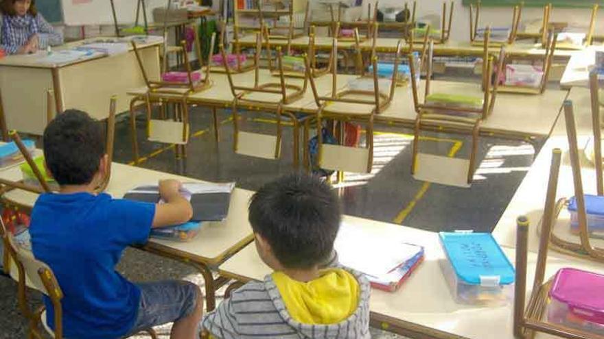 Alumnos en un aula junto a su profesora.