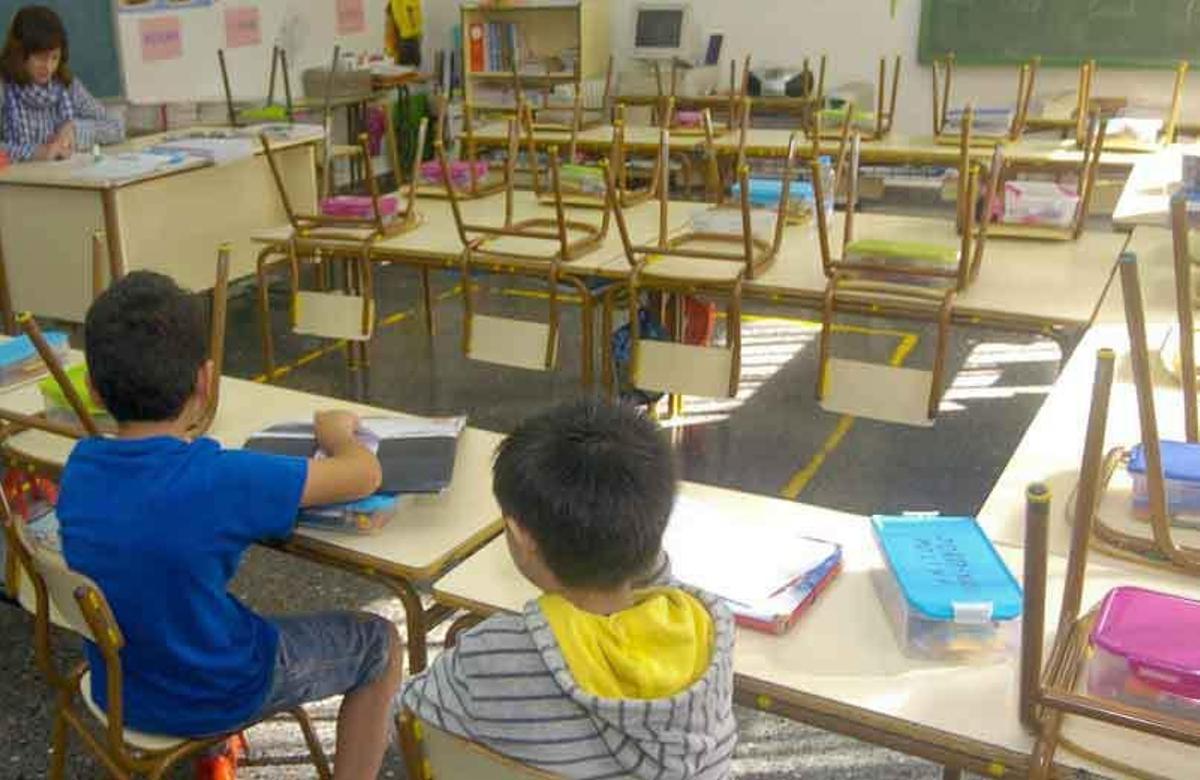 Alumnos en un aula junto a su profesora.