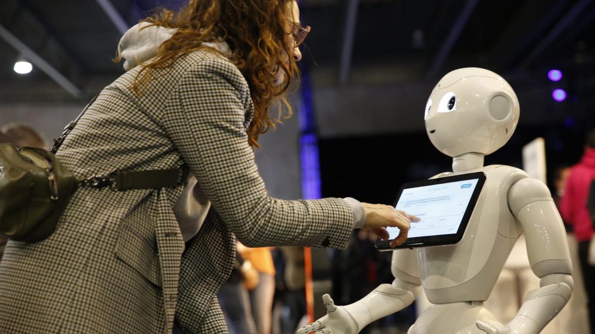 Una asistente al 4YFN interactúa con el robot que ha traído Mediktor