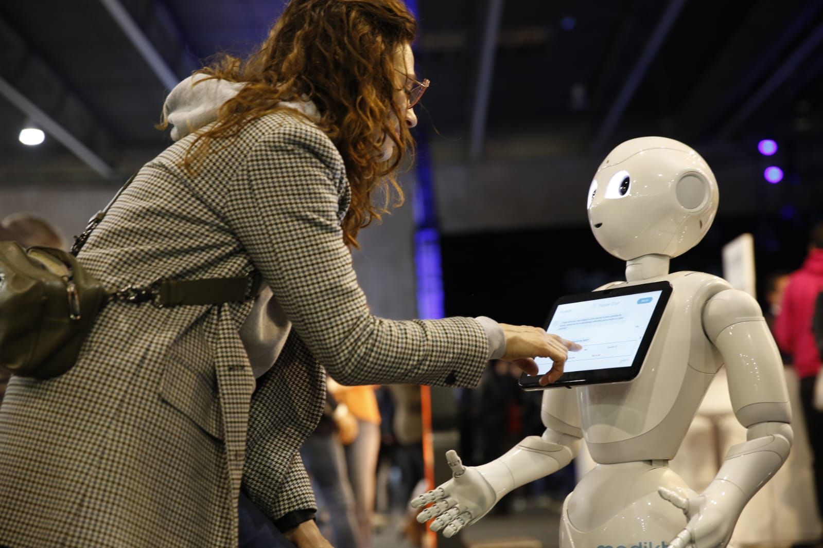 Una asistente al 4YFN interactúa con el robot que ha traído Mediktor