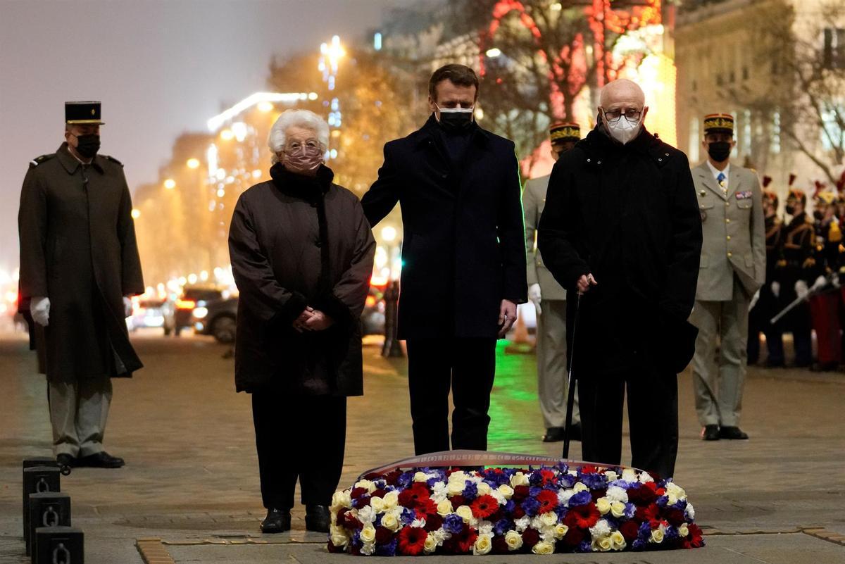 El presidente de Francia, Emmanuel Macron, en el centro, flanqueado por el superviviente del campo de concentración de Auschwitz Esther Senot, segunda por la izquierda, y de Bergen-Belsen, Victor Perahia, a la derecha, ante la Tumba del Soldado Desconocido bajo el Arco del Triunfo, en París, Francia.