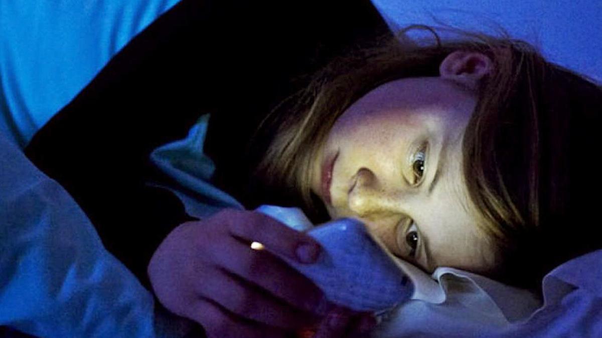 Una nena consulta el mòbil abans d’anar a dormir.  | FDV/PIM