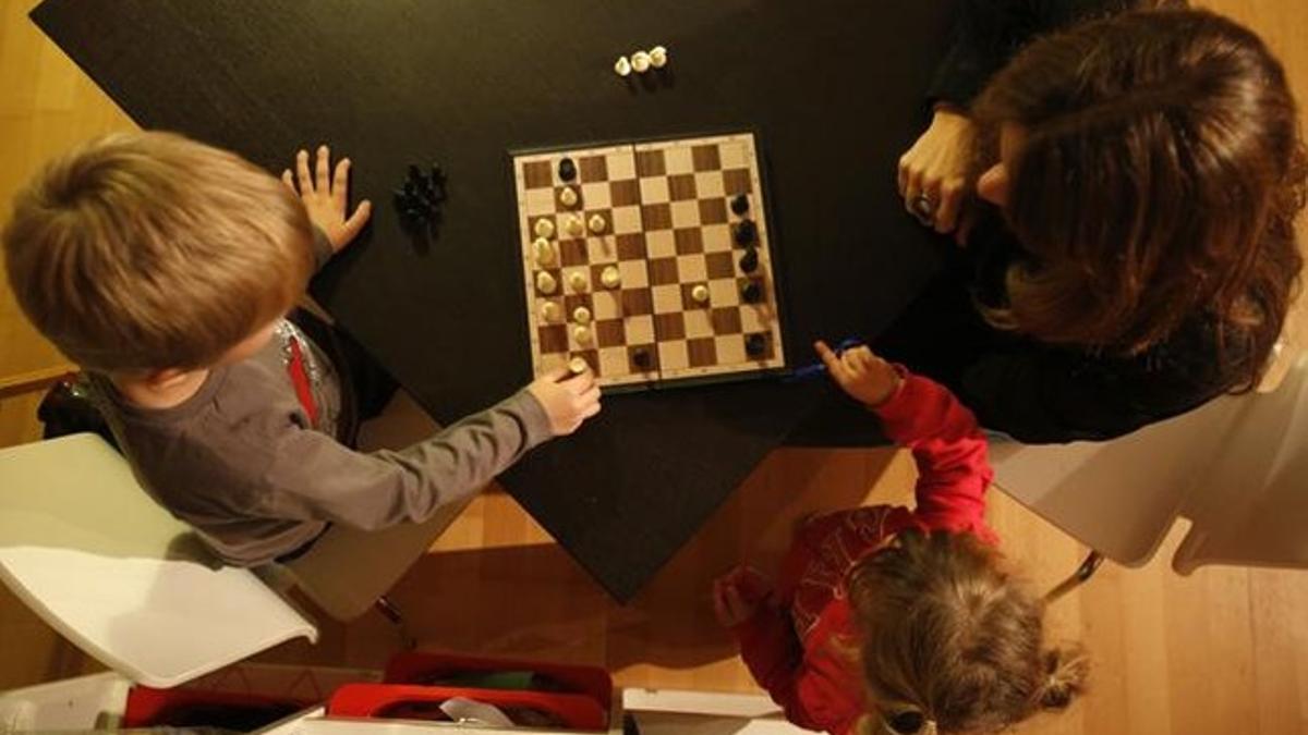 Patrícia juega al ajedrez con su hijo Héctor, de cinco años.