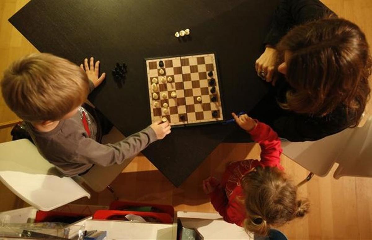 Patrícia juega al ajedrez con su hijo Héctor, de cinco años.