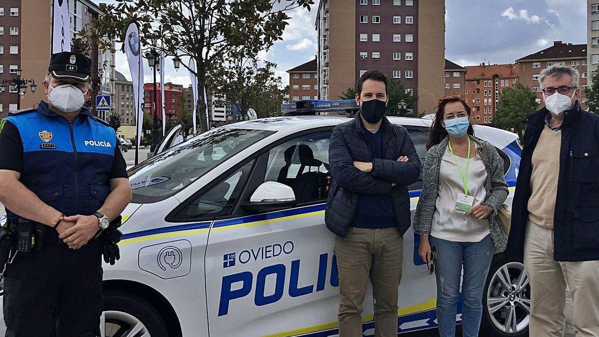 Por la izquierda, el subinspector Bernardo, Jorge Fernández Mier, la coordinadora de la muestra, Begoña Honrado, e Ignacio Ruiz Latierro, junto al vehículo híbrido de la Policía Local expuesto.