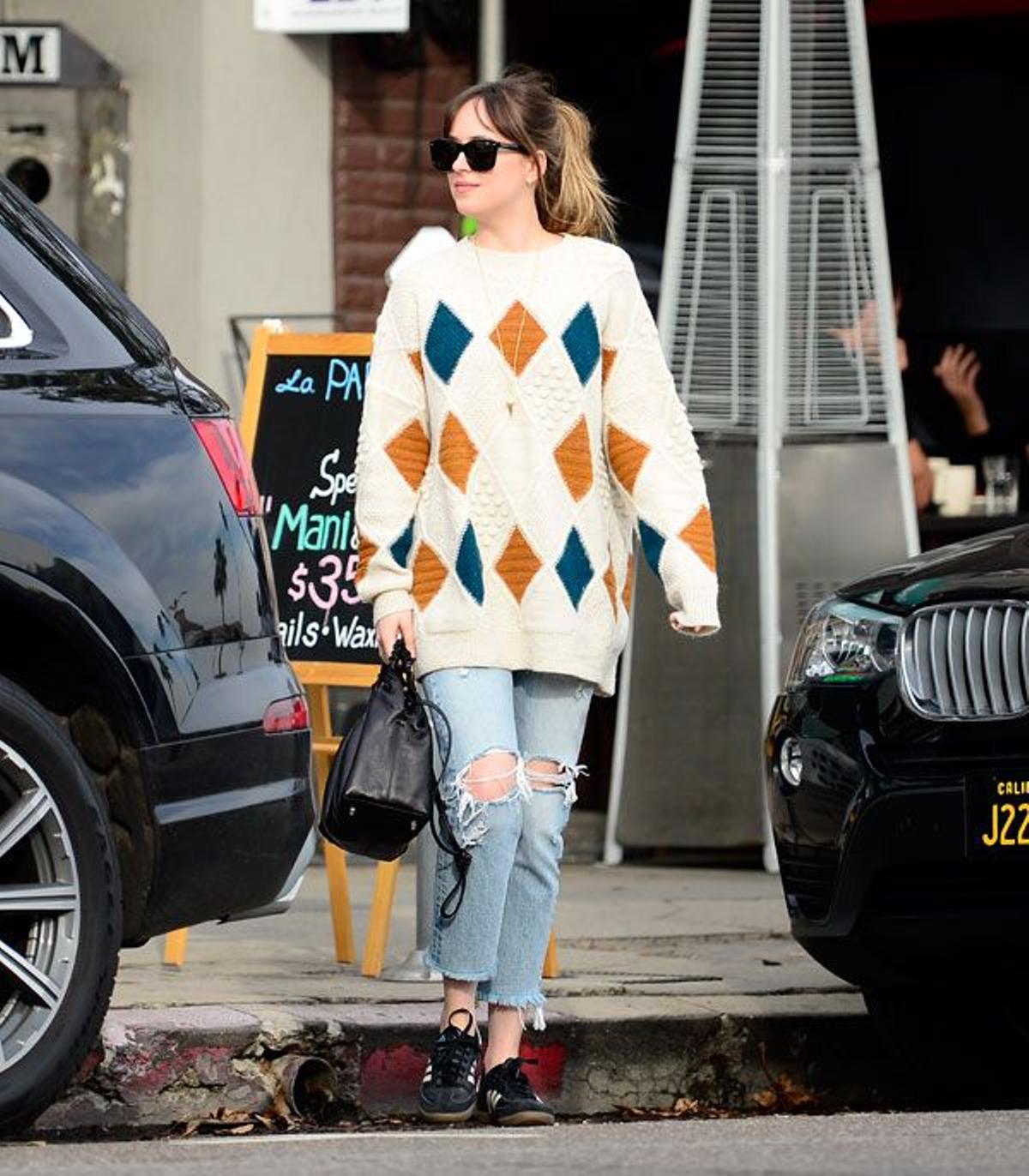 Dakota Johnson con jersey de rombos y pantalones vaqueros