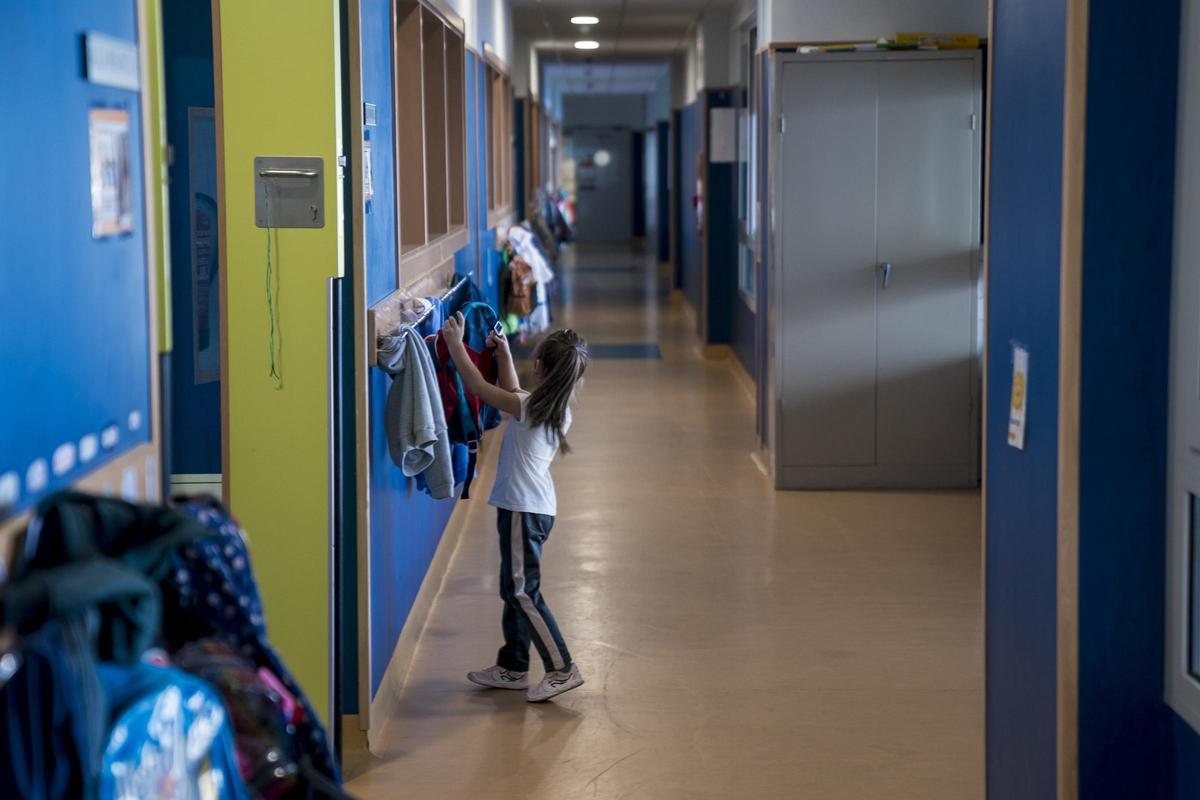 Una niña cuelga su mochila en un perchero en el Colegio público de Educación Infantil y Primaria San Juan Bautista.