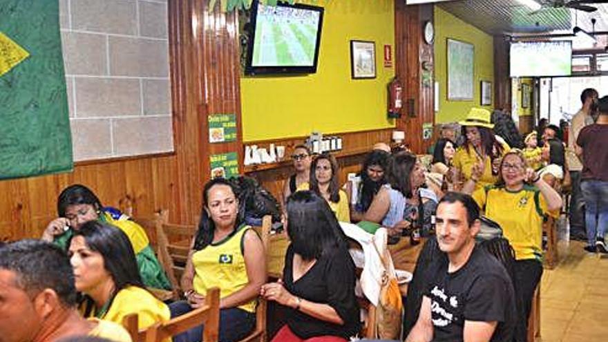 Aficionados brasileños presencian un partido de su selección en un bar de A Coruña.