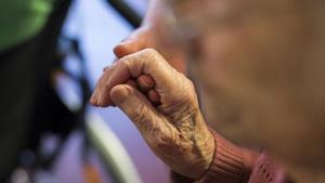 Un cuidador toma la mano de una anciana en una residencia de Berlín.