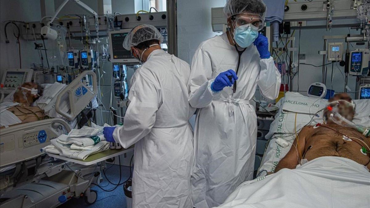 Sanitarios atienden a un enfermo de covid en la uci del Hospital Clínic.