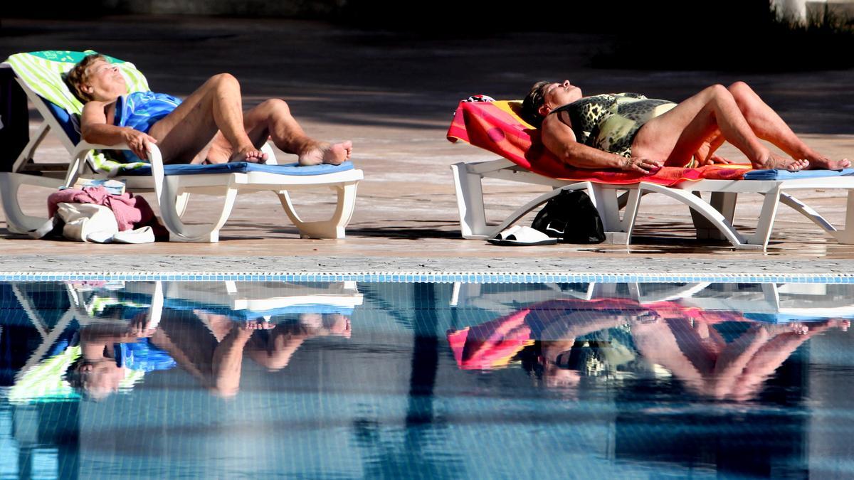 Dos mujeres toman el sol en la piscina de un hotel de Benidorm