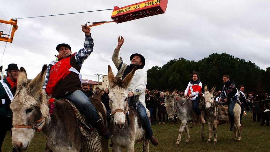 Uno de los &quot;quintos&quot; saca una cinta del cajón, mientras su compañero intenta atrapar otra.