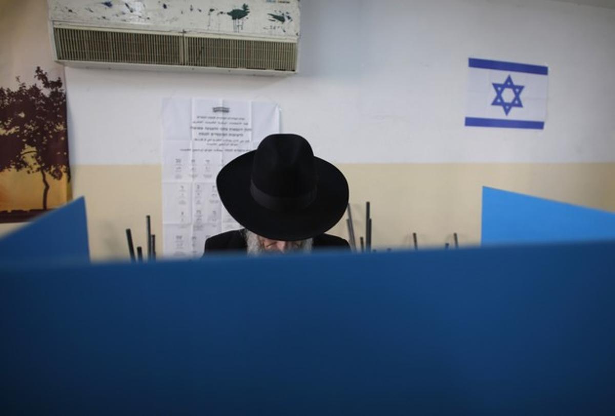 Un jueu ultraortodox diposita el seu vot, aquest dimarts, en un col·legi electoral a Jerusalem.