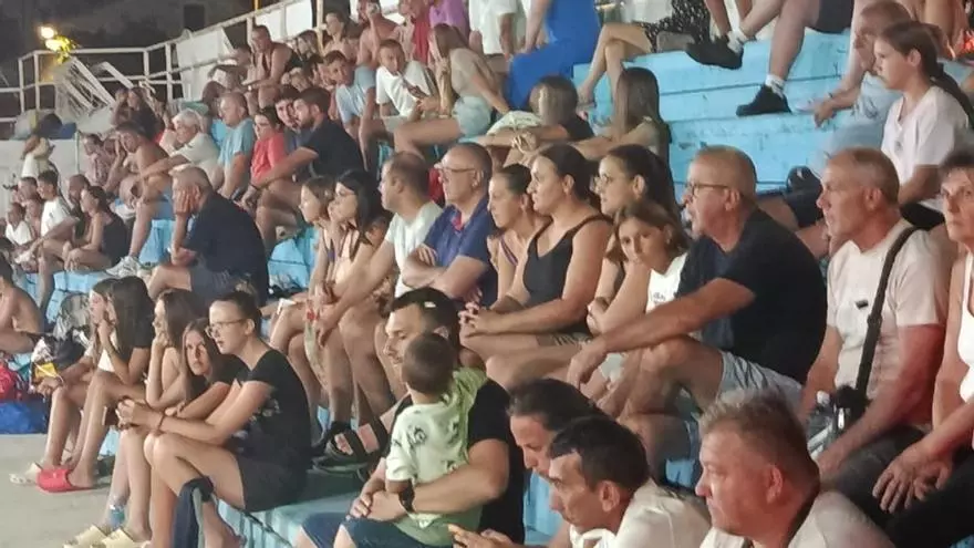 Un aficionado con una bengala, rodeado de muchos aficionados, en un partido amistoso de waterpolo en Montenegro.