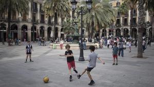 Niños del Gòtic juegan a fútbol en la plaza del Rei, el pasado jueves por la tarde