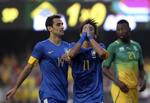 Brazil's Neymar reacts between his teammate Jonas and South Africa's Sangweni during their international friendly soccer match in Sao Paulo