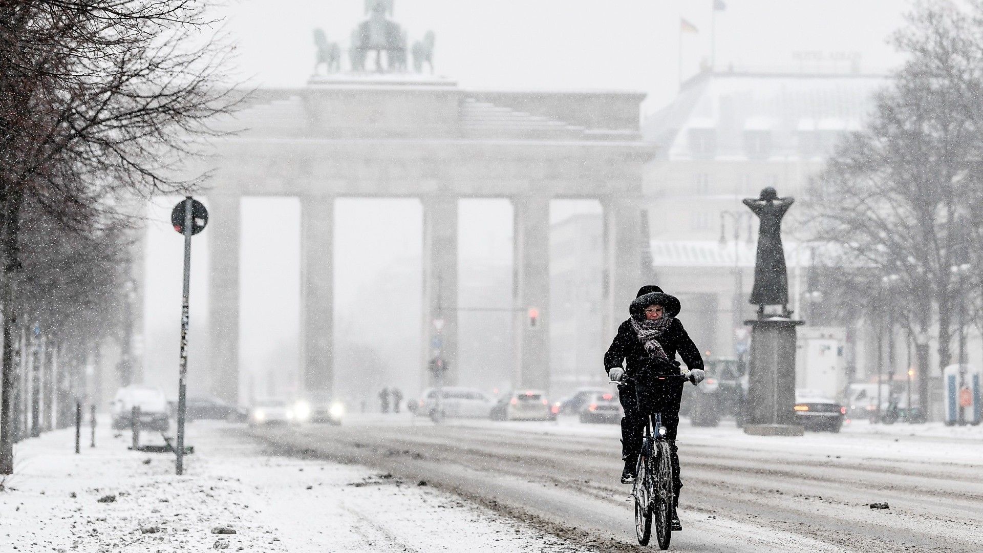Un ciclista circula ante la puerta de Brandenburgo de Berlín durante la nevada del 8 de febrero de 2021
