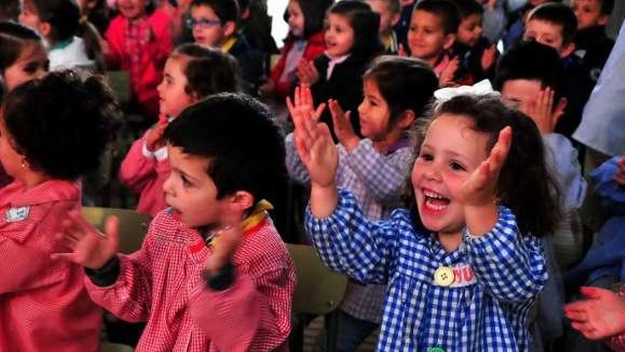 Arriba, los integrantes de la coral (ellas vestidas como en el campo, y ellos de marineros), y a la izquierda, los niños aplauden en A Pastora. // Iñaki Abella