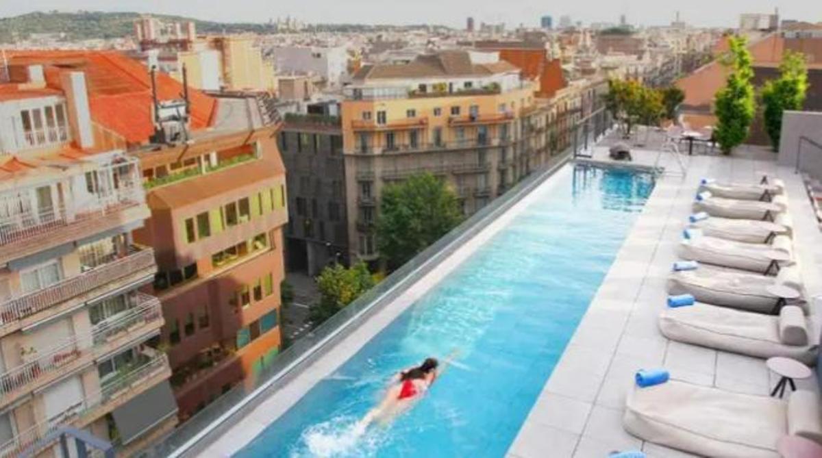 Una mujer se baña en la piscina rooftop del Hotel Ohla del Eixample de Barcelona que oferta estancias de 'staycations'.
