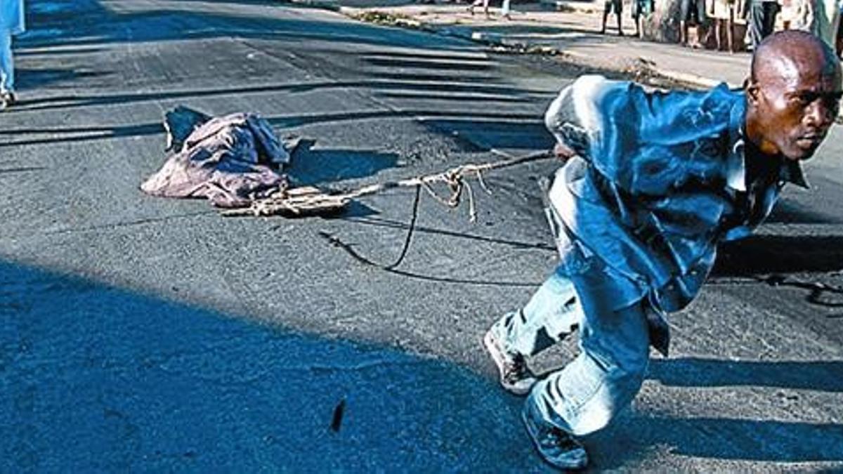 Un hombre traslada a un fallecido por cólera en Cabo Haitiano.