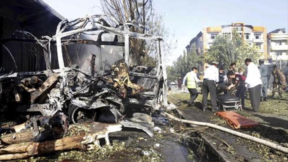 Terror 8Rescate de víctimas entre los restos calcinados del autobús atacado e Kabul.