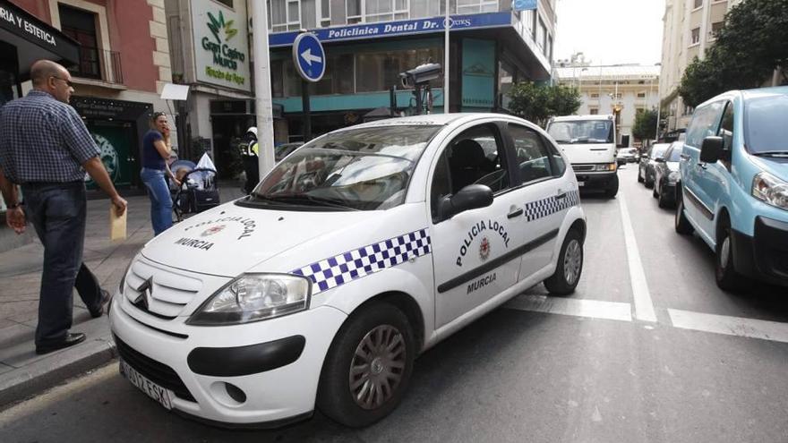 El coche caza-multas de la Policía Local circula por la calle Correos.