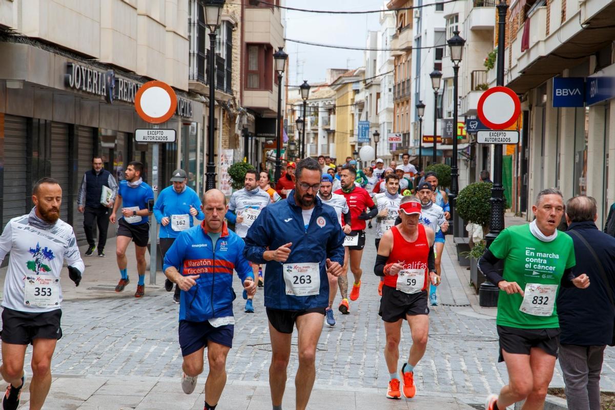 Atletas participantes en la Media Maratón de Lucena atraviesan el centro de la localidad.