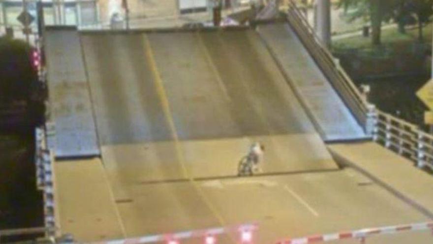 Una ciclista sobrevive de milagro al cruzar un puente levadizo con el semáforo en rojo