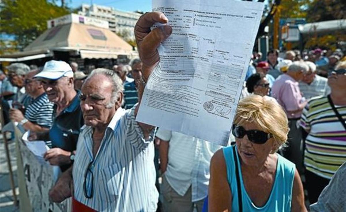 Un pensionista grec mostra el rebut d’un impost durant una manifestació davant el Ministeri de Finances a Atenes.