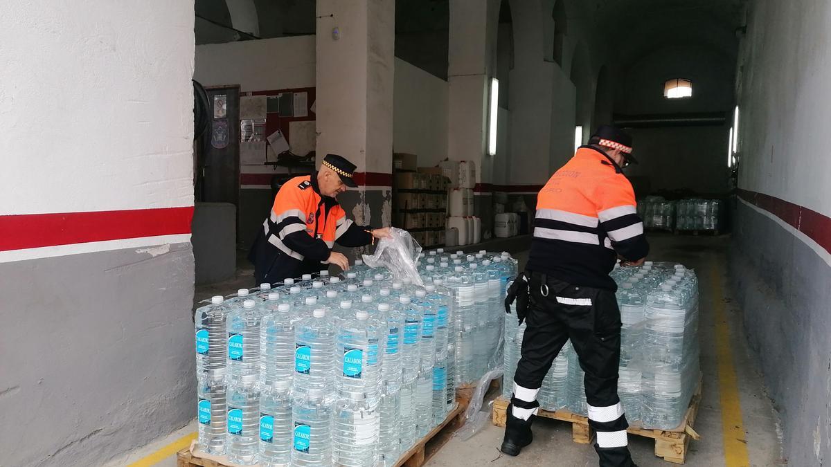 Voluntarios de Protección Civil preparan garrafas de agua para su distribución