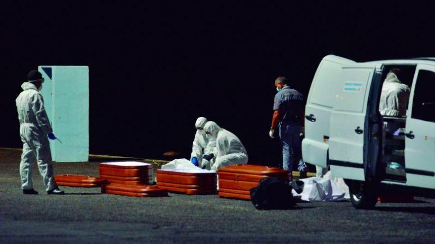 Varios cadáveres son introducidos en ataúdes en un espacio portuario herreño.