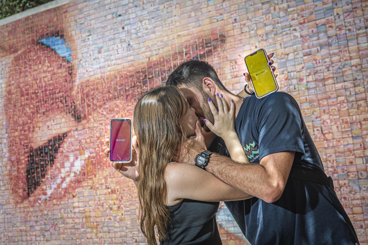 Tinder, capital Barcelona. Con su población creciente de divorciados y separados, la ciudad es un escenario privilegiado de las citas a través de aplicaciones. En la imagen, una pareja se besa frente al mural del beso de Joan Fontcuberta.