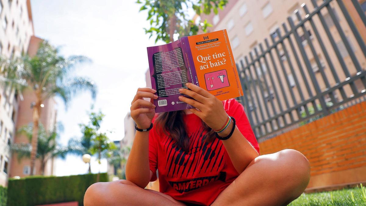 Una joven lee un libro en valenciano sobre sexualidad