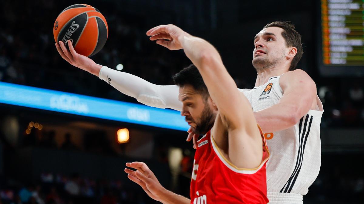 El alero croata del Real Madrid, Mario Hezonja, entra a canasta ante el escolta de Olympiacos, Kostas Papanikolaou, durante el tercer enfrentamiento de playoffs