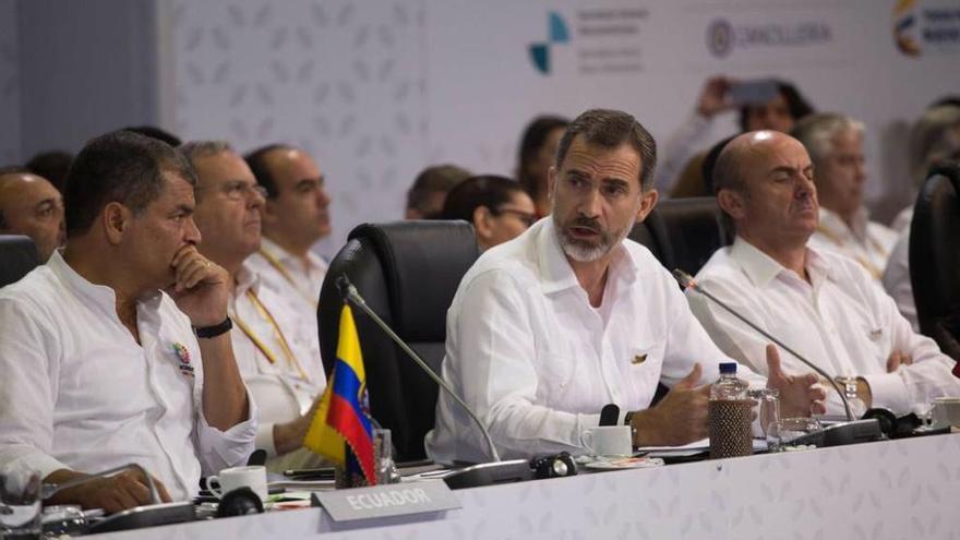 El Rey, flanqueado por el presidente ecuatoriano, Rafael Correa, y el ministro de Economía en funciones, Luis de Guindos.