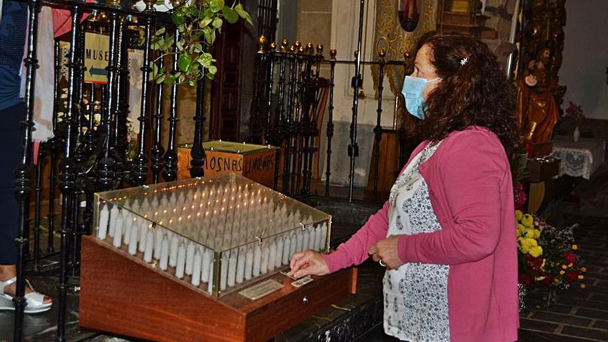 Una devota ofrece una vela encendida a la Virgen. | A. S.