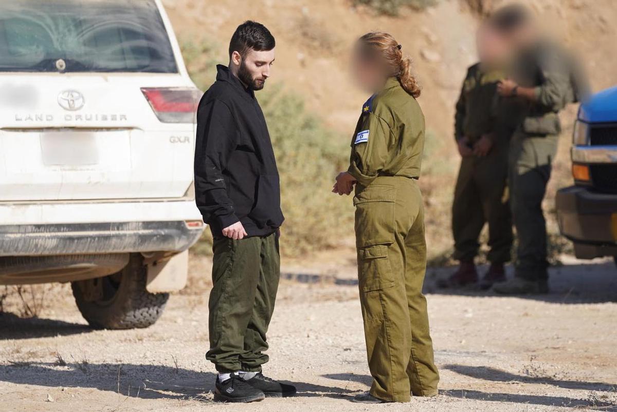 Imagen tomada en la base militar israelí de Reim en la que aparece un militar israelí conversando con Matan Angrest, uno de los rehenes liberados por Hamás.
