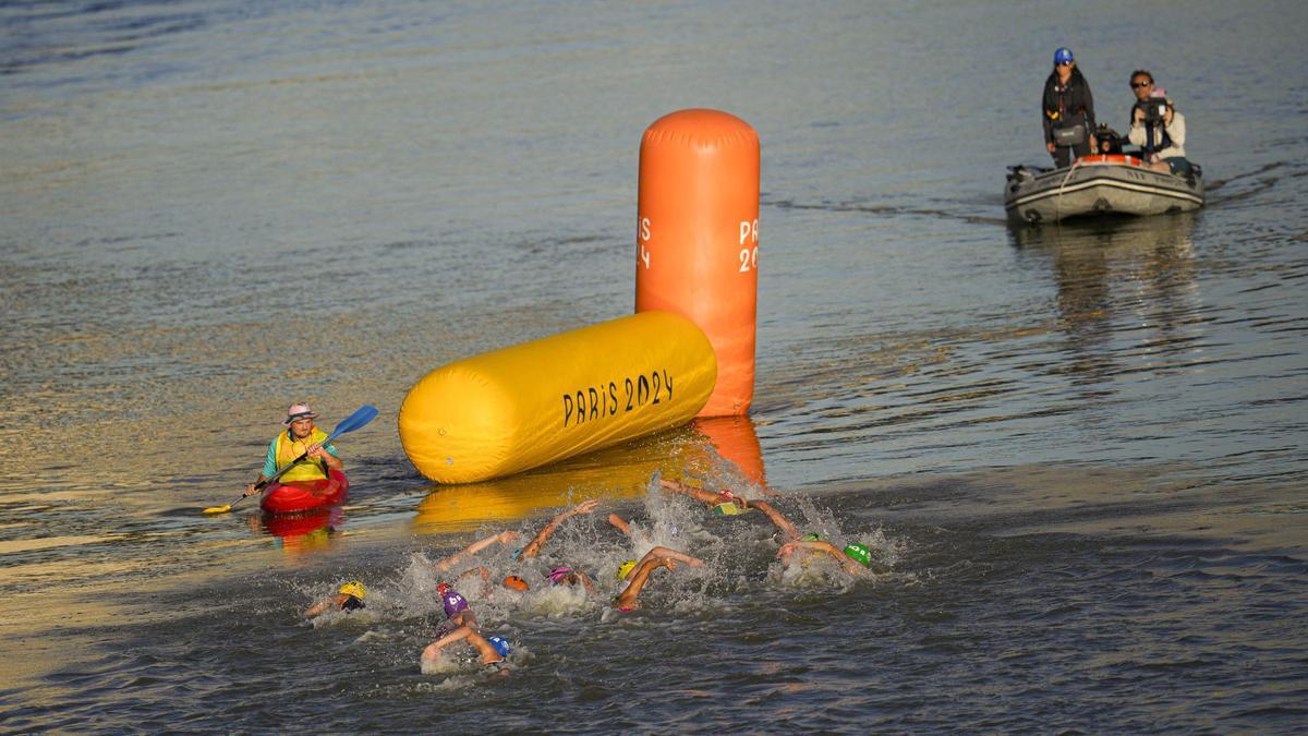 Los participantes nadan en el río Sena durante la prueba de natación del triatlón de relevos mixtos en los Juegos Olímpicos de Paris 2024