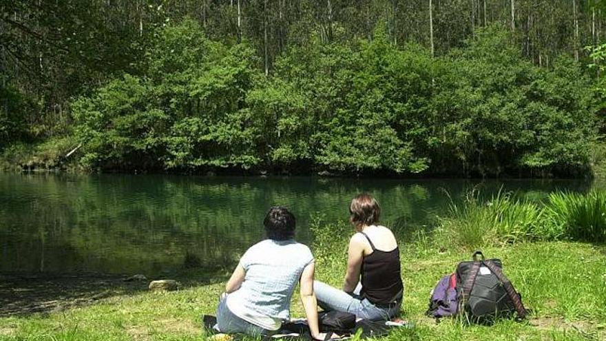 Dos personas observan el río Eume a su paso por As Fragas. / l. o.