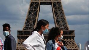 Gente con mascarilla pasea por Trocadero, cerca de la Torre Eiffel, en París.