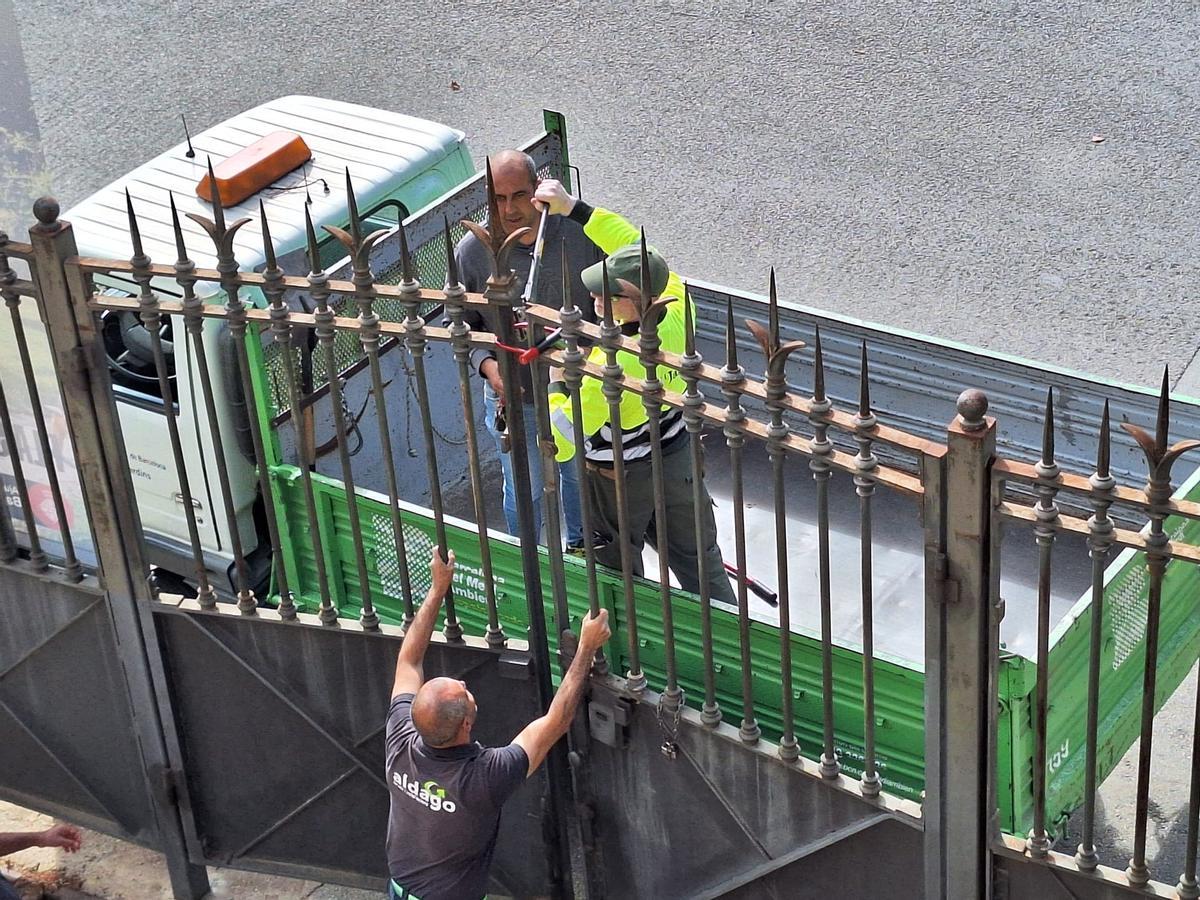 Un operario rompe el candado que cerraba la puerta principal del parque del Castell de l'Oreneta, en Barcelona, este lunes.