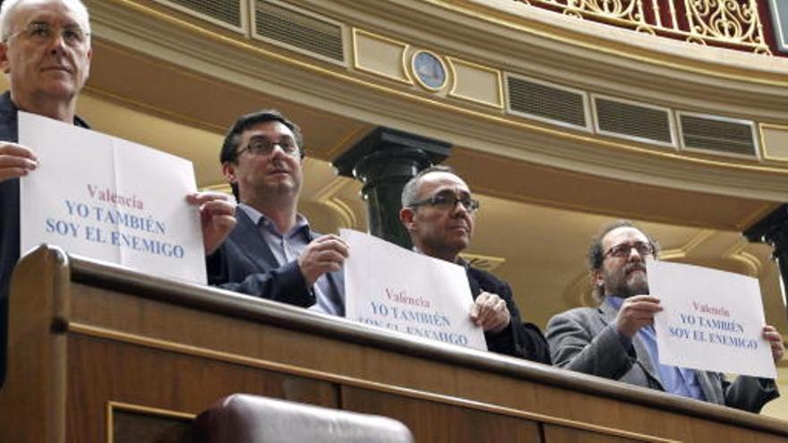 Cayo Lara y otros diputados de su grupo parlamentario sostienen un cartel con el lema &quot;Yo también soy el enemigo&quot;.