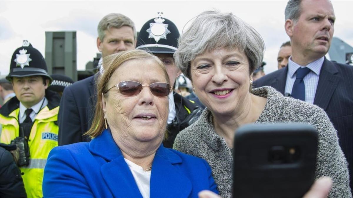 May (derecha) posa para un selfi con una asistente a una exhibición militar en Liverpool, el 24 de junio.