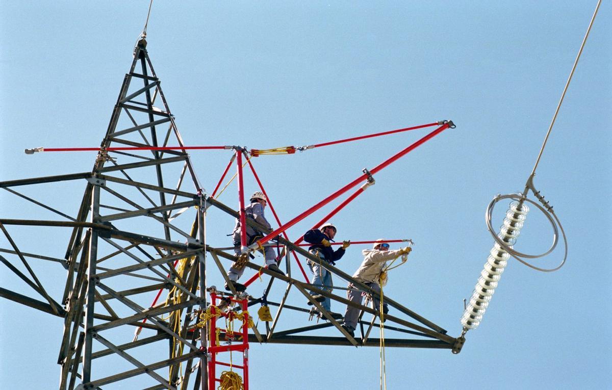 Operarios arreglando una línea de alta tensión. | REDEIA