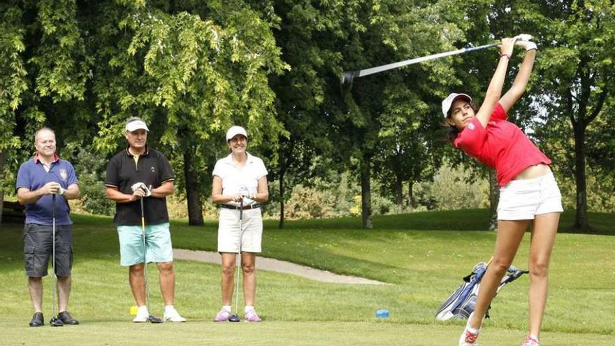 Mariana Echevarría finaliza su golpe en el tee del hoyo 15 ante Manuel Álvarez, Saturnino Sánchez y Ana Rodríguez.