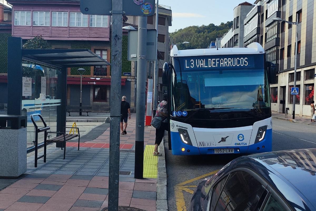 Pasajaros subiendo a un bus en Mieres.
