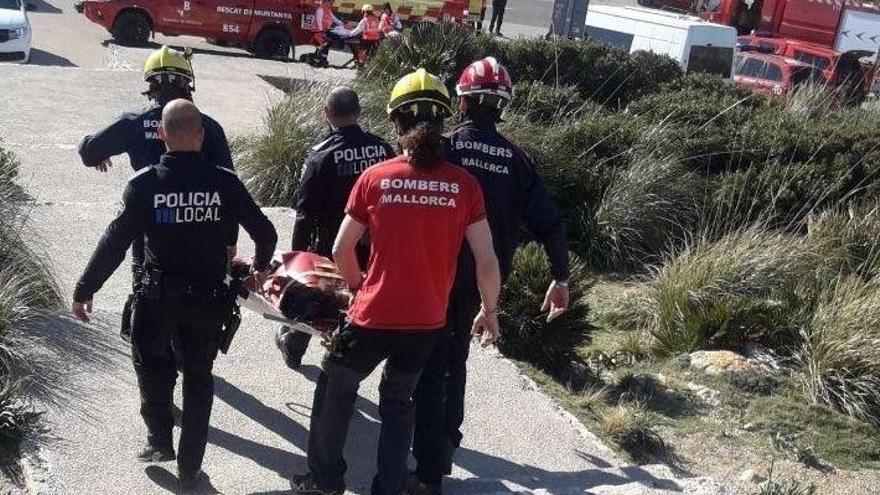 Feuerwehrleute und Polizisten bringen die verletzte Frau zum Krankenwagen.