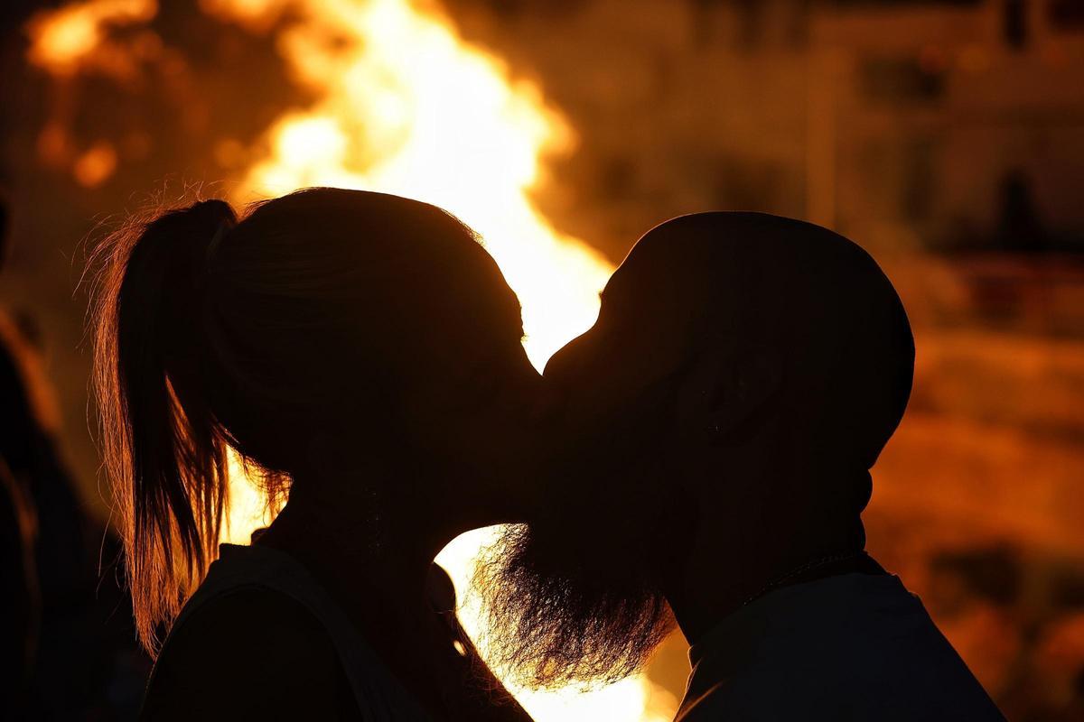 Una pareja en las hogueras de San Juan, organizadas en María Jiménez, barrio de Santa Cruz.